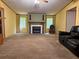 Spacious living room with a cozy fireplace, neutral carpet, and large windows offering natural light and wooded views at 148 Boogers Hill Rd, Oxford, GA 30054