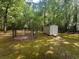 Storage shed in the backyard, near a fenced enclosure, surrounded by trees at 148 Boogers Hill Rd, Oxford, GA 30054