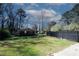 Large backyard with a black fence surrounding the green lawn and detached garage at 1616 W Kellogg Cir, Douglasville, GA 30134
