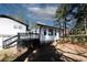 Backyard view showcases a large, freshly painted white home with a black deck and a chain-link fence at 1616 W Kellogg Cir, Douglasville, GA 30134