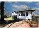 Backyard view features freshly painted home with white siding and black accents and deck at 1616 W Kellogg Cir, Douglasville, GA 30134