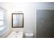 Bathroom with window, tiled shower and large mirror over a single sink at 1616 W Kellogg Cir, Douglasville, GA 30134