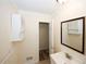 Well-lit bathroom featuring a wooden-framed mirror, vanity, and small storage cabinet at 1616 W Kellogg Cir, Douglasville, GA 30134