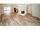 Open-concept living room with fireplace, hardwood floors, and adjacent sunroom and kitchen at 1616 W Kellogg Cir, Douglasville, GA 30134