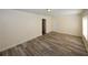Spacious living room featuring laminate flooring, white door, and multiple windows at 1616 W Kellogg Cir, Douglasville, GA 30134