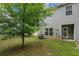 A backyard featuring a healthy, green lawn, a small tree, and a patio with an entrance to the home at 3565 Brycewood Dr, Decatur, GA 30034