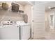 Convenient laundry room with modern washer, dryer, storage shelves, and an ironing board at 3565 Brycewood Dr, Decatur, GA 30034