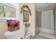Bathroom showcasing a tile shower, a decorative floral arrangement, and neutral walls at 3919 Mccullers Rd, Loganville, GA 30052