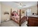 Bedroom featuring a four poster bed, neutral carpeting, a ceiling fan, and a writing desk at 3919 Mccullers Rd, Loganville, GA 30052