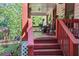 Inviting front porch with red railings, complete with rocking chairs and lush plants at 3919 Mccullers Rd, Loganville, GA 30052