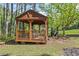 Backyard featuring a wood gazebo with a grill in a beautiful wooded setting at 3919 Mccullers Rd, Loganville, GA 30052