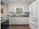 Bright kitchen featuring white cabinets, stainless appliances, and wood-look floors at 3919 Mccullers Rd, Loganville, GA 30052