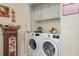 Laundry room with modern washer and dryer, cabinet storage, and neutral paint at 3919 Mccullers Rd, Loganville, GA 30052