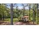 Property featuring a shed sitting in a wooded lot with abundant green space at 3919 Mccullers Rd, Loganville, GA 30052