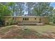 Brick home's backyard with a large deck and wooded area at 4420 Lake Breeze Dr, Stone Mountain, GA 30083