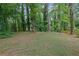 Backyard featuring grassy area with mature trees, and wooded perimeter at 4420 Lake Breeze Dr, Stone Mountain, GA 30083