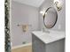 Bathroom boasts a gray vanity, round mirror, and modern lighting at 4420 Lake Breeze Dr, Stone Mountain, GA 30083