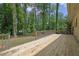 Wide wooden deck with railing overlooks the wooded backyard at 4420 Lake Breeze Dr, Stone Mountain, GA 30083