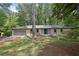 Charming brick home with a two-car garage, lush greenery, and a welcoming front entrance at 4420 Lake Breeze Dr, Stone Mountain, GA 30083