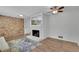 Bright living room with a brick accent wall, fireplace and modern ceiling fan at 4420 Lake Breeze Dr, Stone Mountain, GA 30083