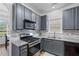 A modern kitchen featuring gray cabinets, stainless steel appliances, and granite countertops at 6045 Park Close, Fairburn, GA 30213