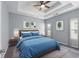 Main bedroom showcasing a tray ceiling, ceiling fan, and plush king bed at 6045 Park Close, Fairburn, GA 30213
