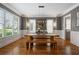 Bright dining room features a wooden table and bench, hardwood floors, and large windows that provide great light at 2685 Grady Se St, Smyrna, GA 30080