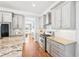 Open kitchen with stainless steel appliances, granite counters, and gray cabinets at 2685 Grady Se St, Smyrna, GA 30080