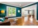 Inviting living room with hardwood floors, large window and tasteful teal accent wall and light brown leather couch at 2685 Grady Se St, Smyrna, GA 30080