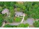 Aerial view of a brick two-story home featuring a manicured yard, professional landscaping, pool and mature trees at 452 Brushstroke Se Ct, Marietta, GA 30067