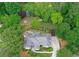 Aerial view of a grey roof two-story home featuring a manicured yard, landscaping and mature trees at 452 Brushstroke Se Ct, Marietta, GA 30067