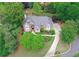 Bird's eye view of a traditional brick home with mature trees, a winding driveway, and expertly maintained landscaping at 452 Brushstroke Se Ct, Marietta, GA 30067