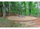 Backyard features lush green grass, mature trees and a gravel seating area with a hammock at 452 Brushstroke Se Ct, Marietta, GA 30067