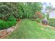 An expansive backyard with plush green grass, surrounded by verdant trees and rock borders at 452 Brushstroke Se Ct, Marietta, GA 30067