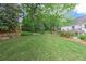 Spacious backyard featuring lush green grass, landscaping and a charming two-story home at 452 Brushstroke Se Ct, Marietta, GA 30067