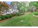 Beautiful backyard featuring lush green grass, colorful landscaping, and a charming white house at 452 Brushstroke Se Ct, Marietta, GA 30067