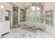 Bright bathroom featuring a marble shower, bathtub, and a large window with white shutters at 452 Brushstroke Se Ct, Marietta, GA 30067