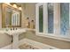 Powder room featuring pedestal sink, decorative mirror, towel rack and stained-glass windows at 452 Brushstroke Se Ct, Marietta, GA 30067