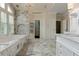 Bright bathroom featuring a bathtub in front of a window with white shutters and chandelier at 452 Brushstroke Se Ct, Marietta, GA 30067