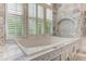 Bright bathroom featuring a bathtub in front of a window with white shutters at 452 Brushstroke Se Ct, Marietta, GA 30067