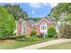 Stately brick home featuring manicured landscaping, large windows, and a well-maintained lawn at 452 Brushstroke Se Ct, Marietta, GA 30067