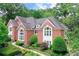 Elegant brick home showcasing mature trees, lush landscaping, and architectural details at 452 Brushstroke Se Ct, Marietta, GA 30067