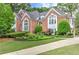 Elegant brick home showcasing a gabled roof and arched windows, enhanced by lush landscaping at 452 Brushstroke Se Ct, Marietta, GA 30067