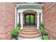Elegant brick home entrance featuring double doors framed by stately columns and lush plants at 452 Brushstroke Se Ct, Marietta, GA 30067