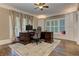 Well-lit home office with custom built-ins, plantation shutters, hardwood floors, and a large desk space at 452 Brushstroke Se Ct, Marietta, GA 30067