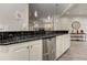 Stylish kitchen bar with dark granite countertops, white cabinets, and stainless steel appliances for modern living at 452 Brushstroke Se Ct, Marietta, GA 30067