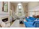 Elegant living room with tall windows, fireplace, built-in shelving, hardwood floors, and high ceilings at 452 Brushstroke Se Ct, Marietta, GA 30067