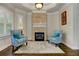 Intimate sitting area with a brick fireplace, hardwood floors, and bright, shuttered windows at 452 Brushstroke Se Ct, Marietta, GA 30067