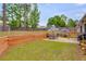 Large, well-maintained backyard with a wood retaining wall, patio, and dining furniture at 5069 Luxford Dr, Douglasville, GA 30135