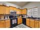 Functional kitchen with wood cabinets, black appliances, and stylish vinyl flooring at 5069 Luxford Dr, Douglasville, GA 30135
